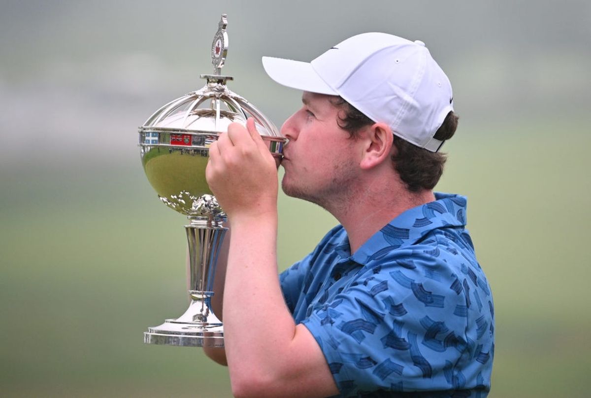 Jun 2, 2024; Hamilton, Ontario, CAN;  Robert MacIntyre kisses the trophy after winning the RBC Canadian Open golf tournament. Mandatory Credit: Dan Hamilton-USA TODAY Sports
