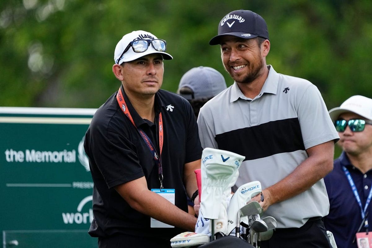 Jun 3, 2024; Columbus, Ohio, USA; Xander Schauffele prepares to tee off on 18 beside his caddie, Austin Kaiser, during a practice round for the Memorial Tournament at Muirfield Village Golf Club.