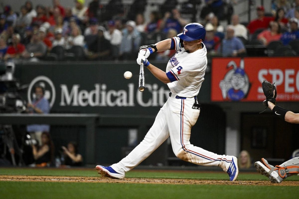 Jun 3, 2024; Arlington, Texas, USA; Texas Rangers shortstop Corey Seager (5) hits a single against the Detroit Tigers during the fifth inning at Globe Life Field. Mandatory Credit: Jerome Miron-USA TODAY Sports