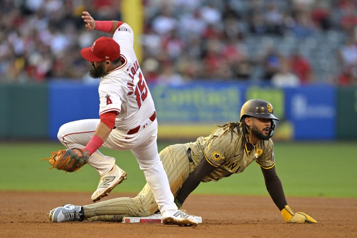 Jun 4, 2024; Anaheim, California, USA;  San Diego Padres right fielder Fernando Tatis Jr. (23) is safe as he dives back to second and avoids a tag by Los Angeles Angels second baseman Luis Guillorme (15) in the third inning at Angel Stadium. Mandatory Credit: Jayne Kamin-Oncea-USA TODAY Sports