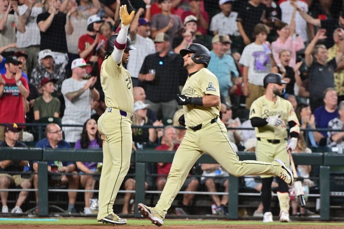 Jun 4, 2024; Phoenix, Arizona, USA;  Arizona Diamondbacks catcher Gabriel Moreno (14) scores and second base Ketel Marte (4) celebrates in the seventh inning against the San Francisco Giants at Chase Field. Mandatory Credit: Matt Kartozian-USA TODAY Sports