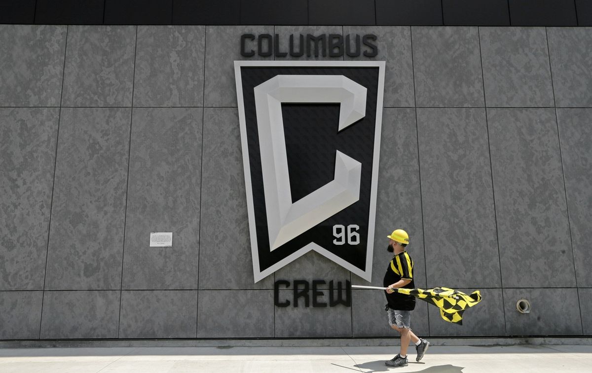 Nick Auddino, of Westerville, walks in front of a Columbus Crew logo on the west side of Lower.com Field before attending the inaugural match between the Columbus Crew and the New England Revolution Saturday. Auddino is a longtime Crew supporter who has only missed one game for the birth of his son. His children Jordan, 12, and Laina, 6, Auddino, were attending the match with him.