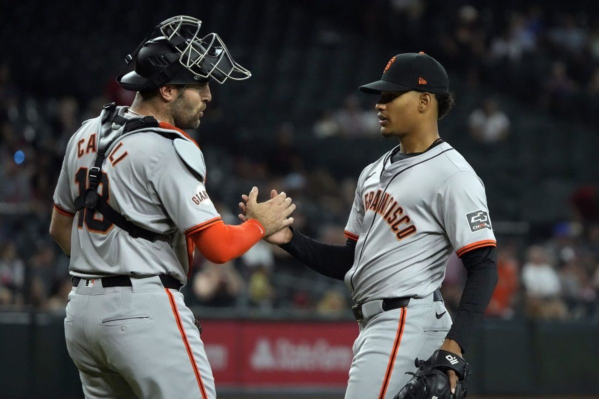 Jun 5, 2024; Phoenix, Arizona, USA; San Francisco Giants catcher Curt Casali (18) and pitcher Randy Rodríguez (73) celebrate after defeating the Arizona Diamondbacks at Chase Field. Mandatory Credit: Rick Scuteri-USA TODAY Sports