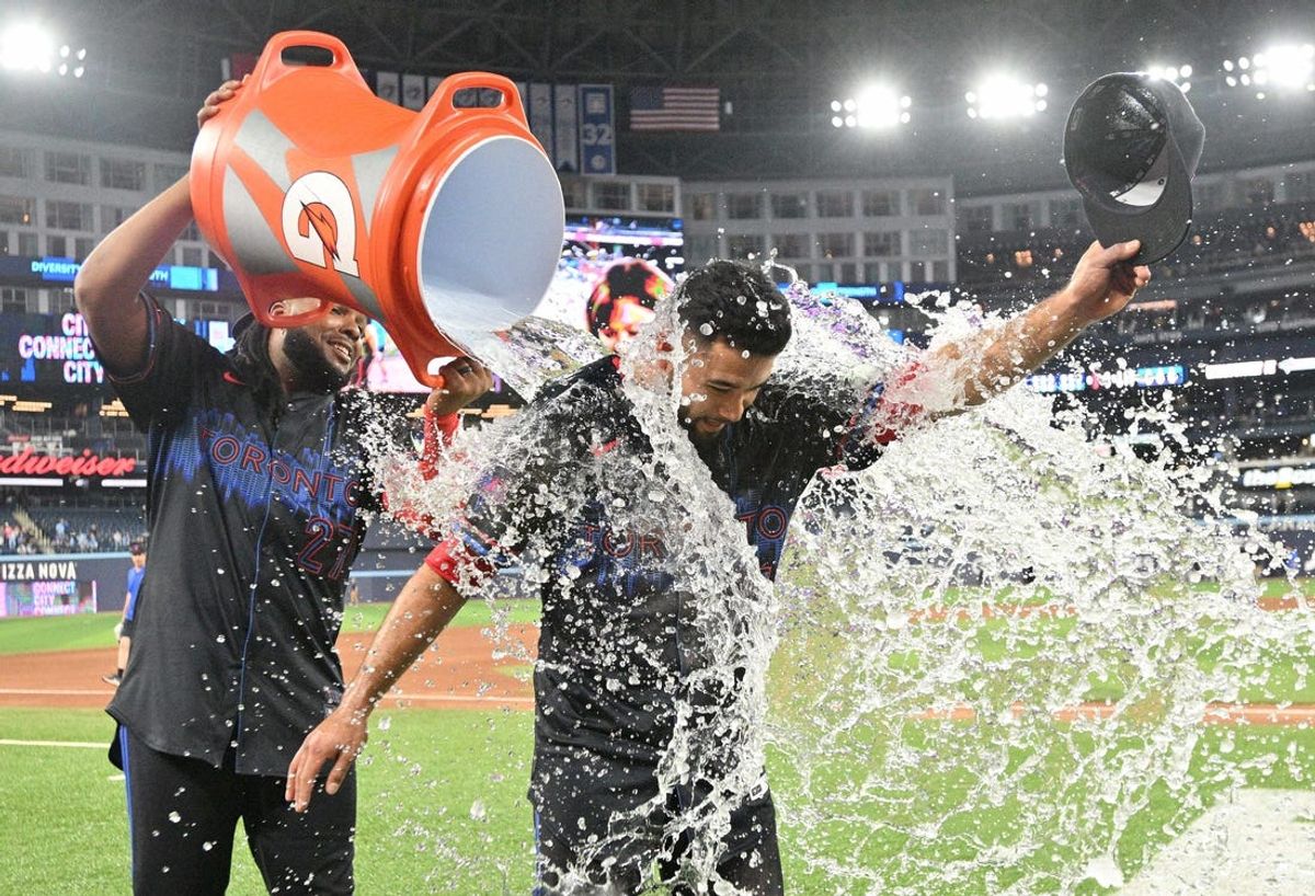 Jun 5, 2024; Toronto, Ontario, CAN;  Toronto Blue Jays third baseman Isiah Kiner-Falefa (7) is doused with ice water by first baseman Vladimir Guerrero Jr. (27) after driving in the winning run in a win over the Baltimore Orioles at Rogers Centre. Mandatory Credit: Dan Hamilton-USA TODAY Sports