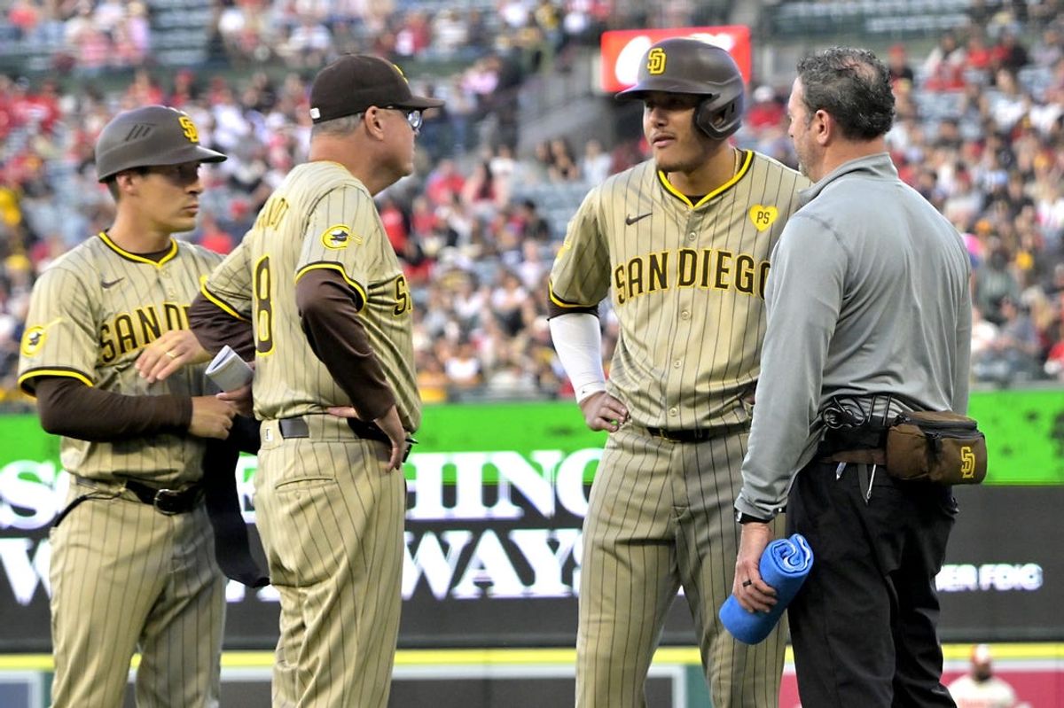 Jun 5, 2024; Anaheim, California, USA;  San Diego Padres third baseman Manny Machado (13) talks with manager Mike Shildt (8) as he leaves the game with an injury in the fourth inning at Angel Stadium. Mandatory Credit: Jayne Kamin-Oncea-USA TODAY Sports