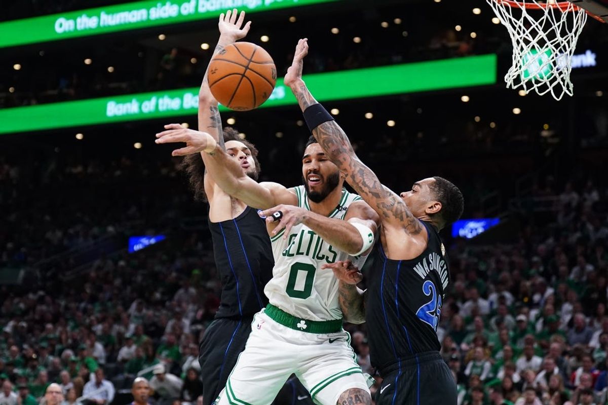 Jun 6, 2024; Boston, Massachusetts, USA; Boston Celtics forward Jayson Tatum (0) passes against Dallas Mavericks center Dereck Lively II (2) and forward P.J. Washington (25) in the third quarter during game one of the 2024 NBA Finals at TD Garden. Mandatory Credit: David Butler II-USA TODAY Sports
