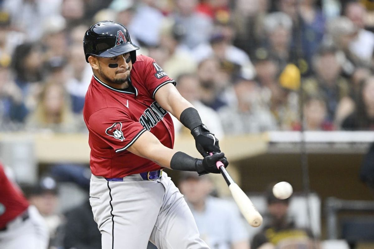 Jun 6, 2024; San Diego, California, USA; Arizona Diamondbacks catcher Gabriel Moreno (14) hits a solo home run during the second inning against the San Diego Padres at Petco Park. Mandatory Credit: Denis Poroy-USA TODAY Sports at Petco Park.