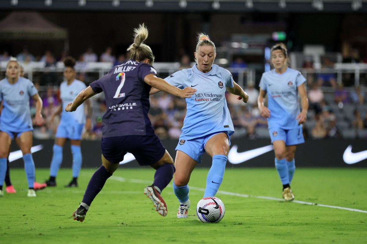 Jun 7, 2024; Louisville, Kentucky, USA; Houston Dash defender Courtney Petersen (8) kicks the ball past Racing Louisville FC defender Lauren Milliet (2) in the second half at Lynn Family Stadium. Mandatory Credit: EM Dash-USA TODAY Sports