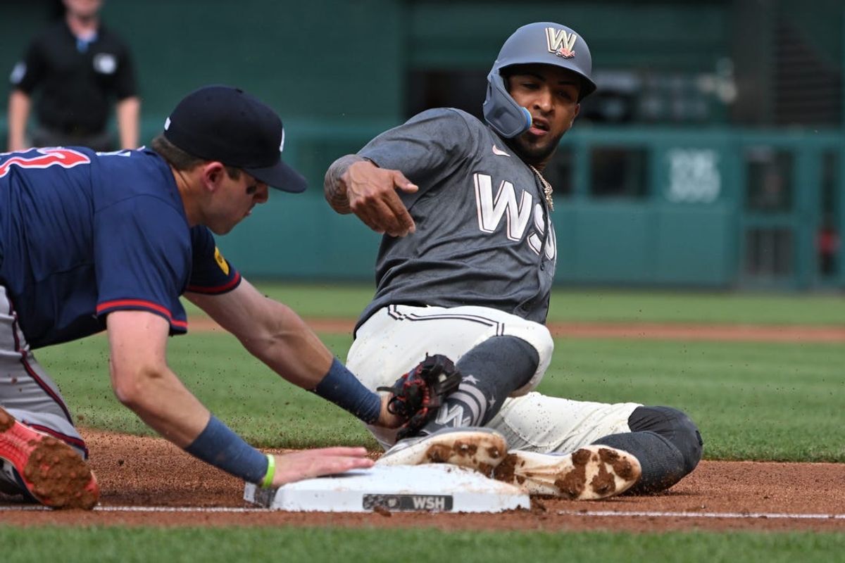 Jun 8, 2024; Washington, District of Columbia, USA; Washington Nationals right fielder Eddie Rosario (8) slides into third base in front of Atlanta Braves third baseman Austin Riley (27) during the first inning at Nationals Park. Mandatory Credit: Rafael Suanes-USA TODAY Sports