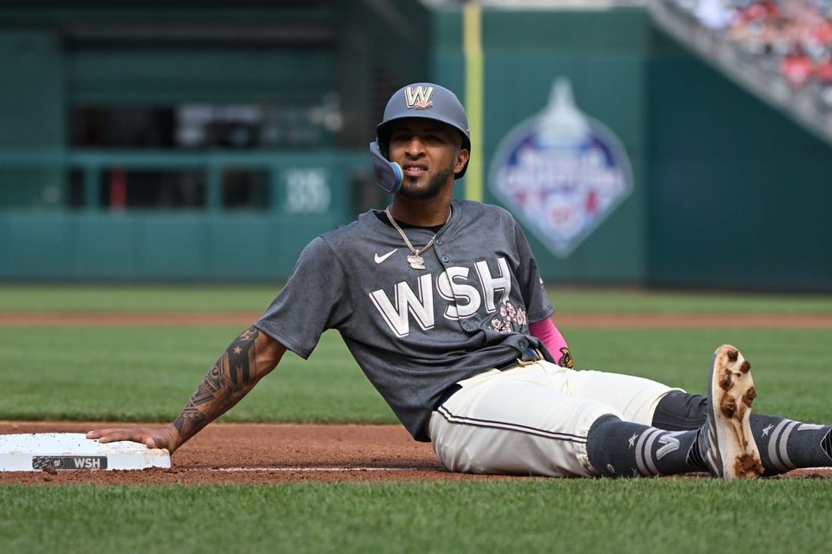 Jun 8, 2024; Washington, District of Columbia, USA; Washington Nationals right fielder Eddie Rosario (8) rests after sliding into third base against the Atlanta Braves during the first inning at Nationals Park. Mandatory Credit: Rafael Suanes-USA TODAY Sports