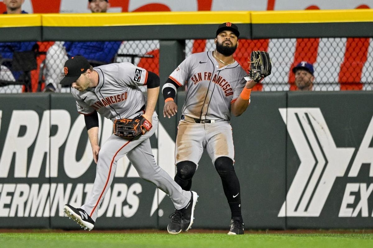 Jun 8, 2024; Arlington, Texas, USA; San Francisco Giants right fielder Austin Slater (13) moves out of the way of center fielder Heliot Ramos (17) as he catches a fly ball hit by Texas Rangers designated hitter Jonah Heim (not pictured) during the fourth inning at Globe Life Field. Mandatory Credit: Jerome Miron-USA TODAY Sports