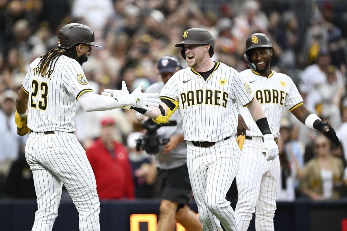 Jun 8, 2024; San Diego, California, USA; San Diego Padres first baseman Jake Cronenworth (9), center, is congratulated by San Diego Padres right fielder Fernando Tatis Jr. (23), left, as Jurickson Profar (10) looks on after hitting a three-run home run during the fourth inning against the Arizona Diamondbacks at Petco Park. Mandatory Credit: Denis Poroy-USA TODAY Sports at Petco Park.