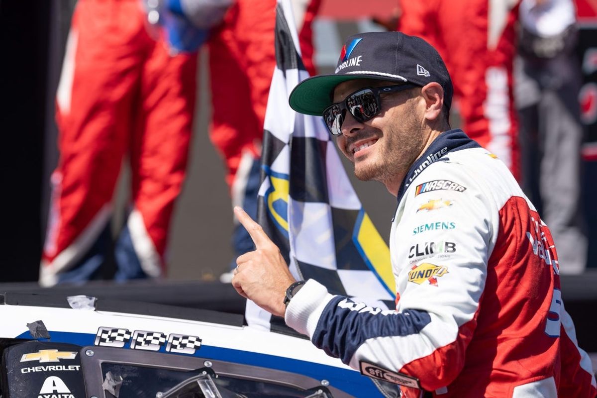 Jun 9, 2024; Sonoma, California, USA;  NASCAR Cup Series driver Kyle Larson (5) celebrates after affixing his third finish flag sticker on his race vehicle after the Toyota / Save Mart 350 at Sonoma Raceway. Mandatory Credit: Stan Szeto-Imagn Images