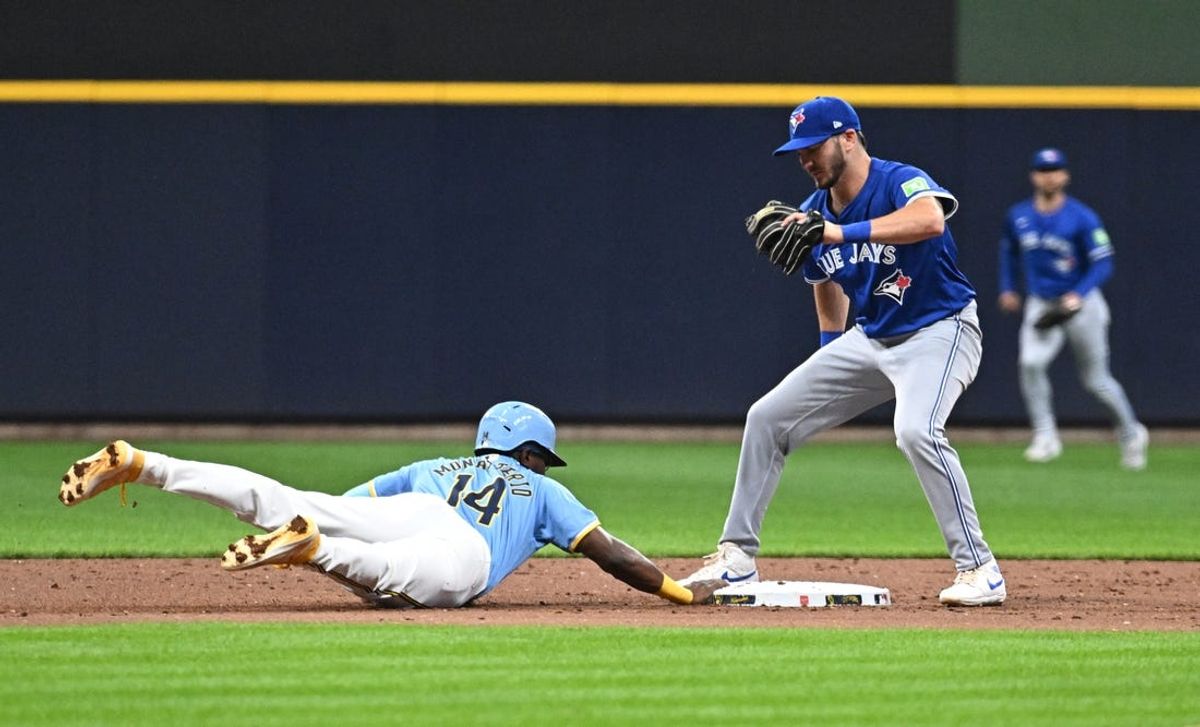 Jun 11, 2024; Milwaukee, Wisconsin, USA; Milwaukee Brewers second base Andruw Monasterio (14) dives safely back to second base ahead of the tag by Toronto Blue Jays outfielder Daulton Varsho (25) in the first inning at American Family Field. Mandatory Credit: Michael McLoone-USA TODAY Sports