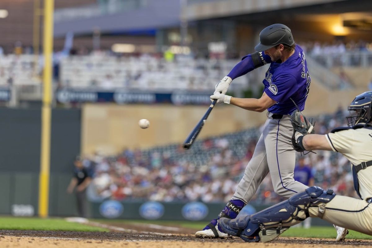 Jun 11, 2024; Minneapolis, Minnesota, USA; Colorado Rockies third baseman Ryan McMahon (24) hits a solo home run against the Minnesota Twins in the eighth inning at Target Field. Mandatory Credit: Jesse Johnson-USA TODAY Sports