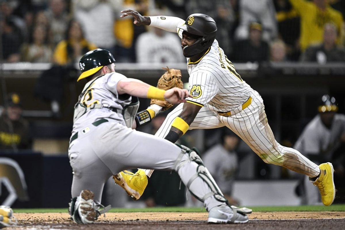 Jun 11, 2024; San Diego, California, USA; San Diego Padres left fielder Jurickson Profar (10) is tagged out at home by Oakland Athletics catcher Kyle McCann (52) during the fifth inning at Petco Park. Mandatory Credit: Orlando Ramirez-USA TODAY Sports