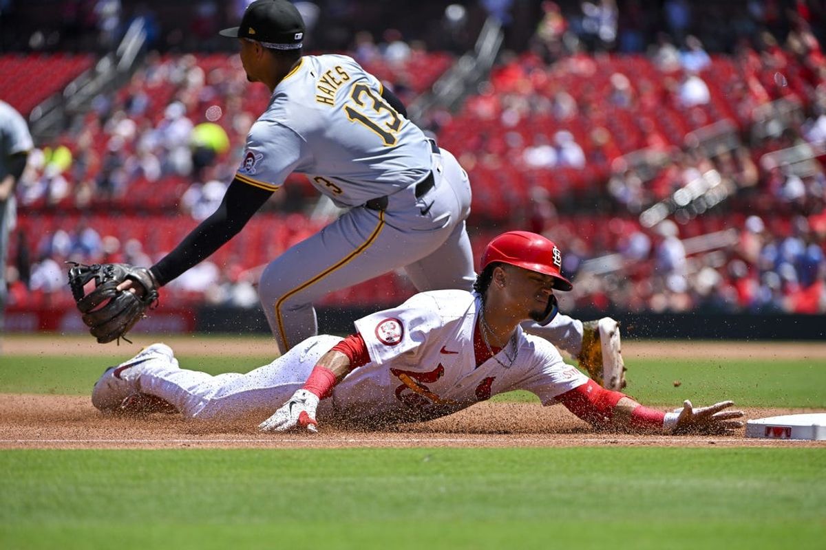 Jun 13, 2024; St. Louis, Missouri, USA;  St. Louis Cardinals shortstop Masyn Winn (0) slides past Pittsburgh Pirates third baseman Ke'Bryan Hayes (13) for a triple during the third inning at Busch Stadium. Mandatory Credit: Jeff Curry-USA TODAY Sports