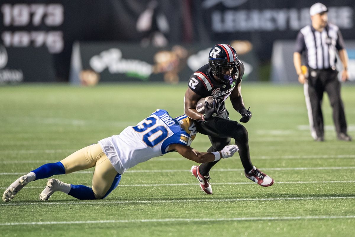 Jun 13, 2024; Ottawa, Ontario, CAN; Winnipeg Blue Bombers defensive back Tyrell Ford (30) tackles Ottawa REDBLACKS wide receiver Dominique Rhymes (15) in the first half at TD Place. Mandatory Credit: Marc DesRosiers-Imagn Images