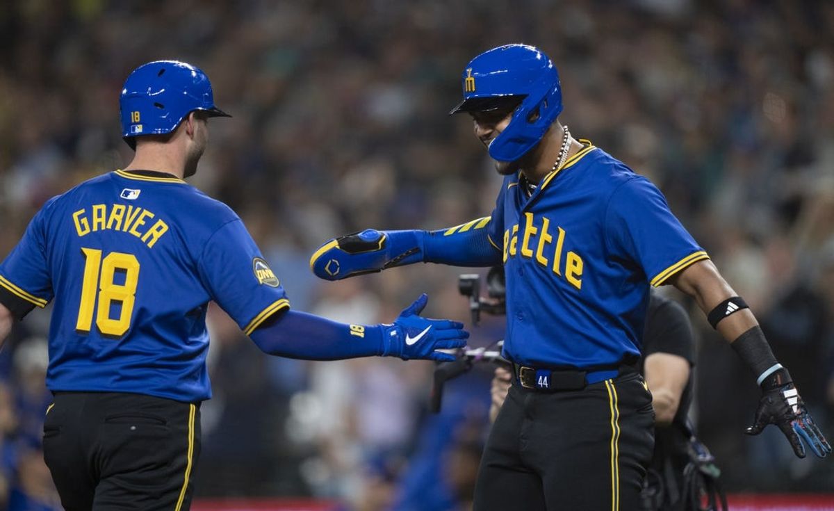 Jun 14, 2024; Seattle, Washington, USA; Seattle Mariners designated hitter Mitch Garver (18) is congratulated by  centerfielder Julio Rodriguez (44) after hitting a two-run home run during the first inning against the Texas Rangers at T-Mobile Park. Mandatory Credit: Stephen Brashear-USA TODAY Sports