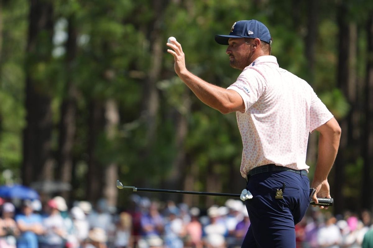 Jun 15, 2024; Pinehurst, North Carolina, USA; Bryson DeChambeau waves to the gallery after putting on the first green during the third round of the U.S. Open golf tournament. Mandatory Credit: John David Mercer-USA TODAY Sports