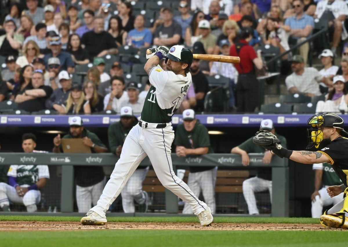 Jun 15, 2024; Denver, Colorado, USA; Colorado Rockies outfielder Jake Cave (11) doubles in the fourth inning against the Pittsburgh Pirates at Coors Field. Mandatory Credit: John Leyba-USA TODAY Sports