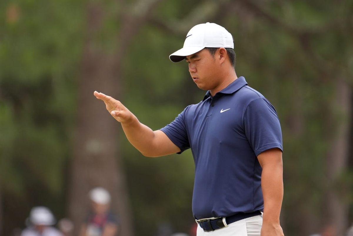 Jun 16, 2024; Pinehurst, North Carolina, USA; Tom Kim prepares to putt on the first green during the final round of the U.S. Open golf tournament. Mandatory Credit: John David Mercer-USA TODAY Sports