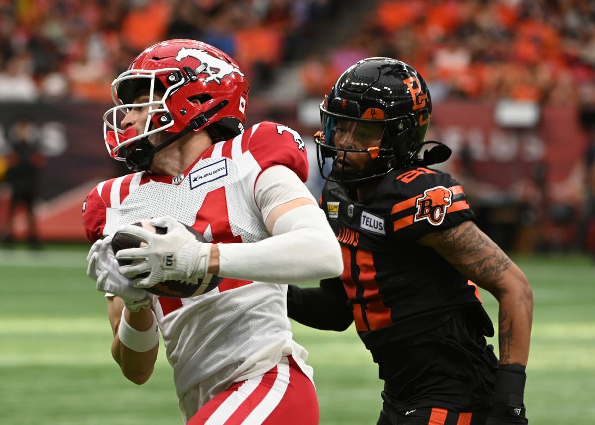 Jun 15, 2024; Vancouver, British Columbia, CAN;  Calgary Stampeders wide receiver Clark Barnes (14) runs with the ball against  BC Lions defensive back Ronald Kent Jr (21) during the second half at BC Place. Mandatory Credit: Simon Fearn-USA TODAY Sports