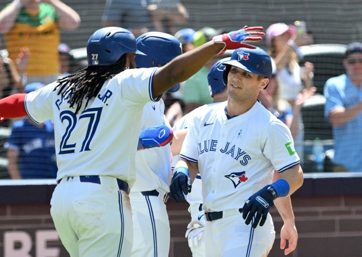 Jun 16, 2024; Toronto, Ontario, CAN;  Toronto Blue Jays center fielder Daulton Varsho (25) is greeted by team mates at home plate after hitting a grand slam home run against the Cleveland Guardians in the fifth inning at Rogers Centre. Mandatory Credit: Dan Hamilton-USA TODAY Sports
