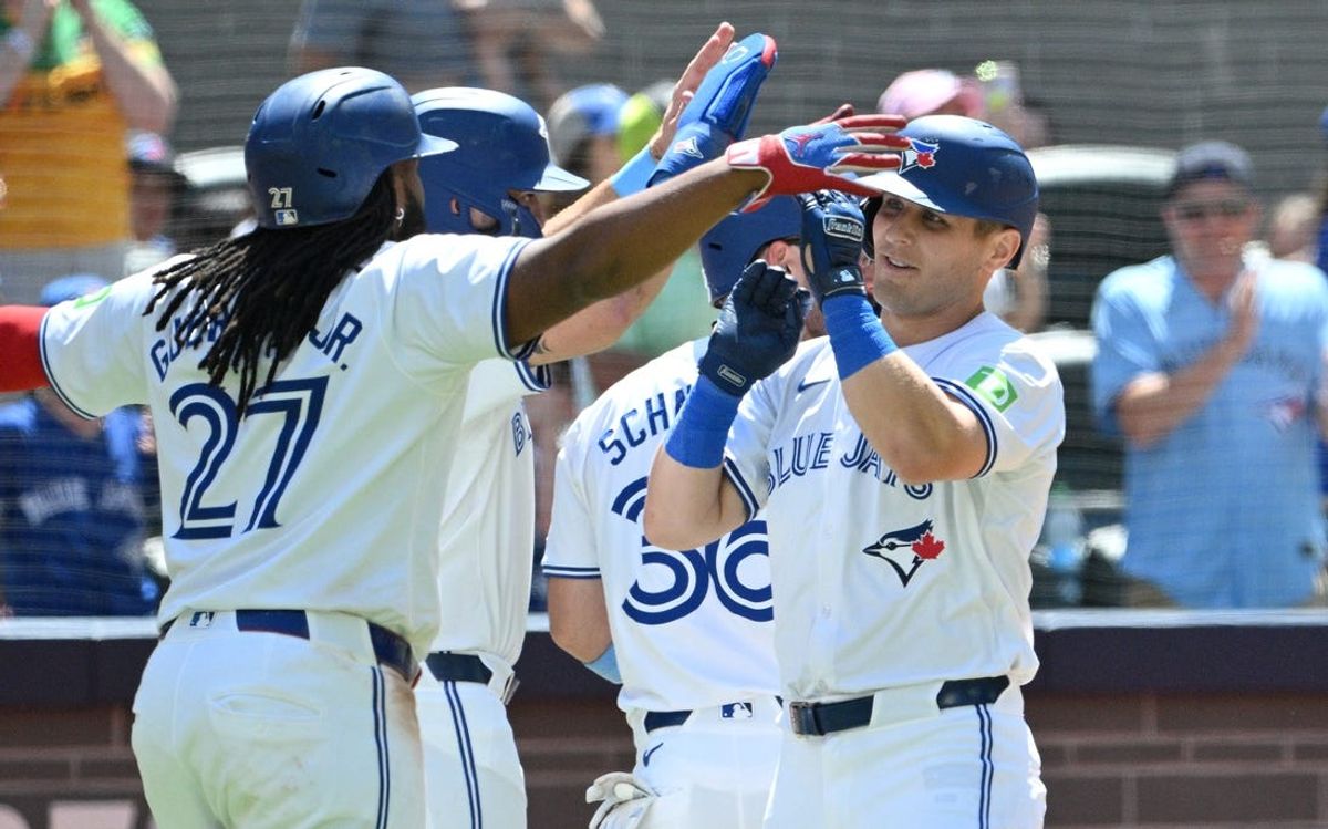 Jun 16, 2024; Toronto, Ontario, CAN;  Toronto Blue Jays center fielder Daulton Varsho (25) is greeted by team mates at home plate after hitting a grand slam home run against the Cleveland Guardians in the fifth inning at Rogers Centre. Mandatory Credit: Dan Hamilton-USA TODAY Sports