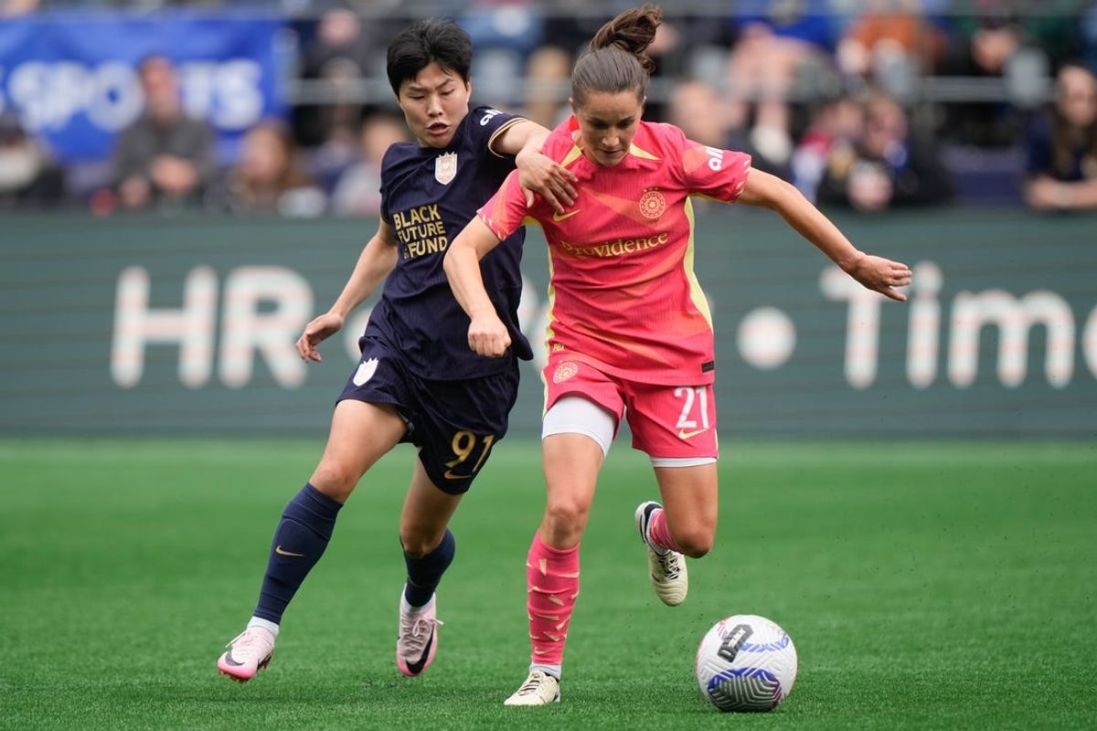 Jun 16, 2024; Seattle, Washington, USA; Portland Thorns FC midfielder Jessie Fleming (21) dribbles away from Seattle Reign FC midfielder Ji So-Yun (91) during the first half at Lumen Field. Mandatory Credit: Stephen Brashear-USA TODAY Sports