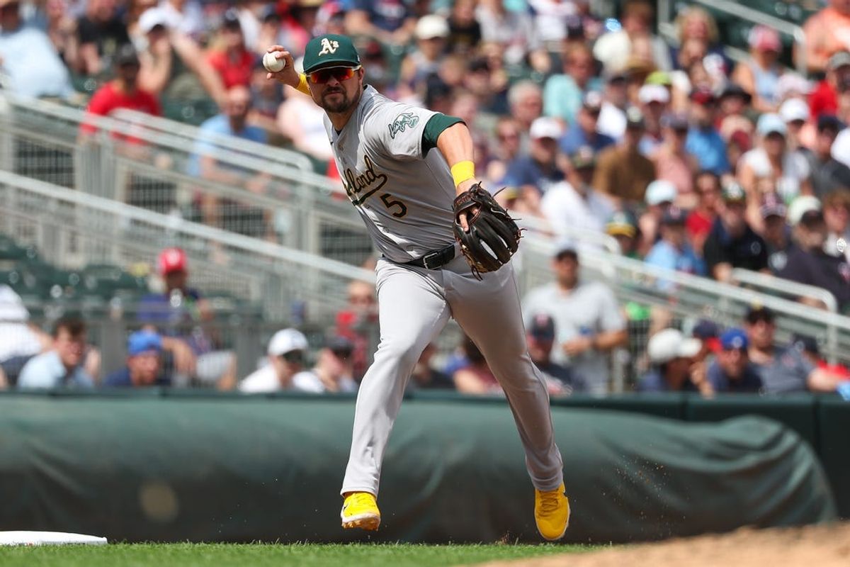 Jun 16, 2024; Minneapolis, Minnesota, USA; Oakland Athletics third baseman J.D. Davis (5) throws the ball to first base to get out Minnesota Twins left fielder Willi Castro (50) during the seventh inning of game one of a double header at Target Field. Mandatory Credit: Matt Krohn-USA TODAY Sports