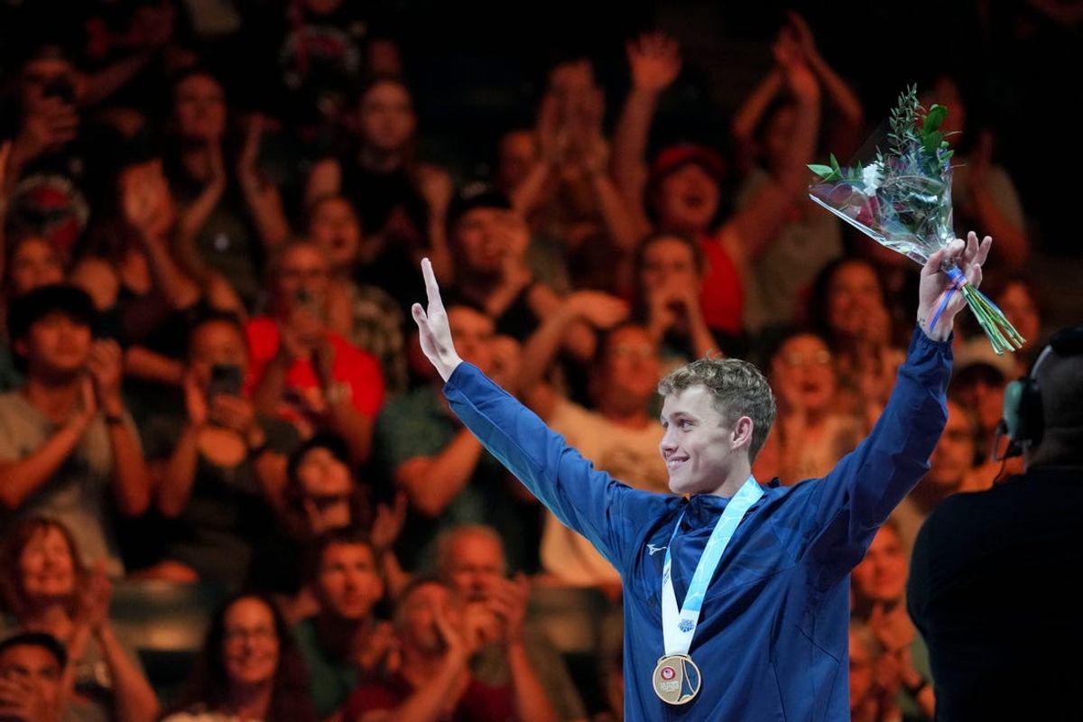 Carson Foster waves to the crowd after receiving his medal for winning the 400-meter individual medley final Sunday, June 16, 2024, during the first day of competition for the U.S. Olympic Team Swimming Trials at Lucas Oil Stadium in Indianapolis.