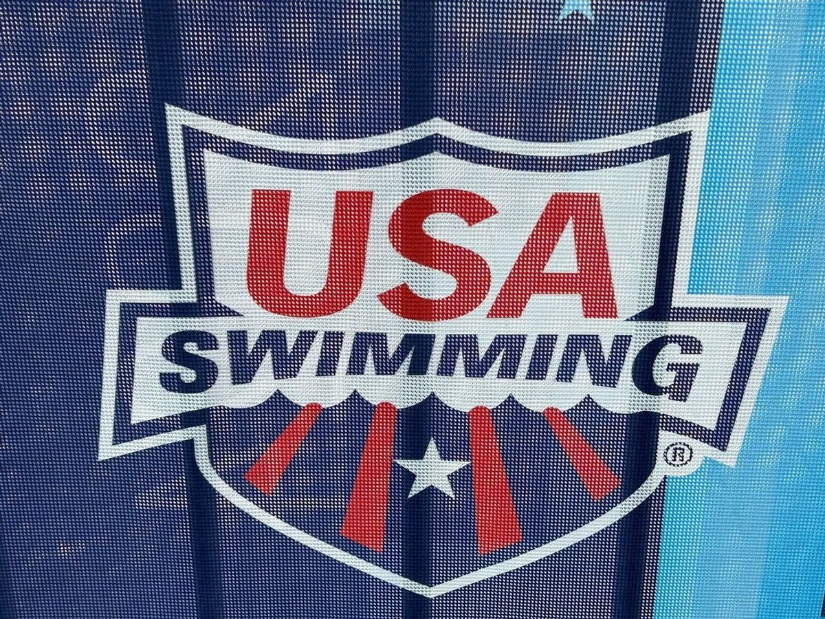 The logo of USA Swimming on a barricade along Georgia Street.