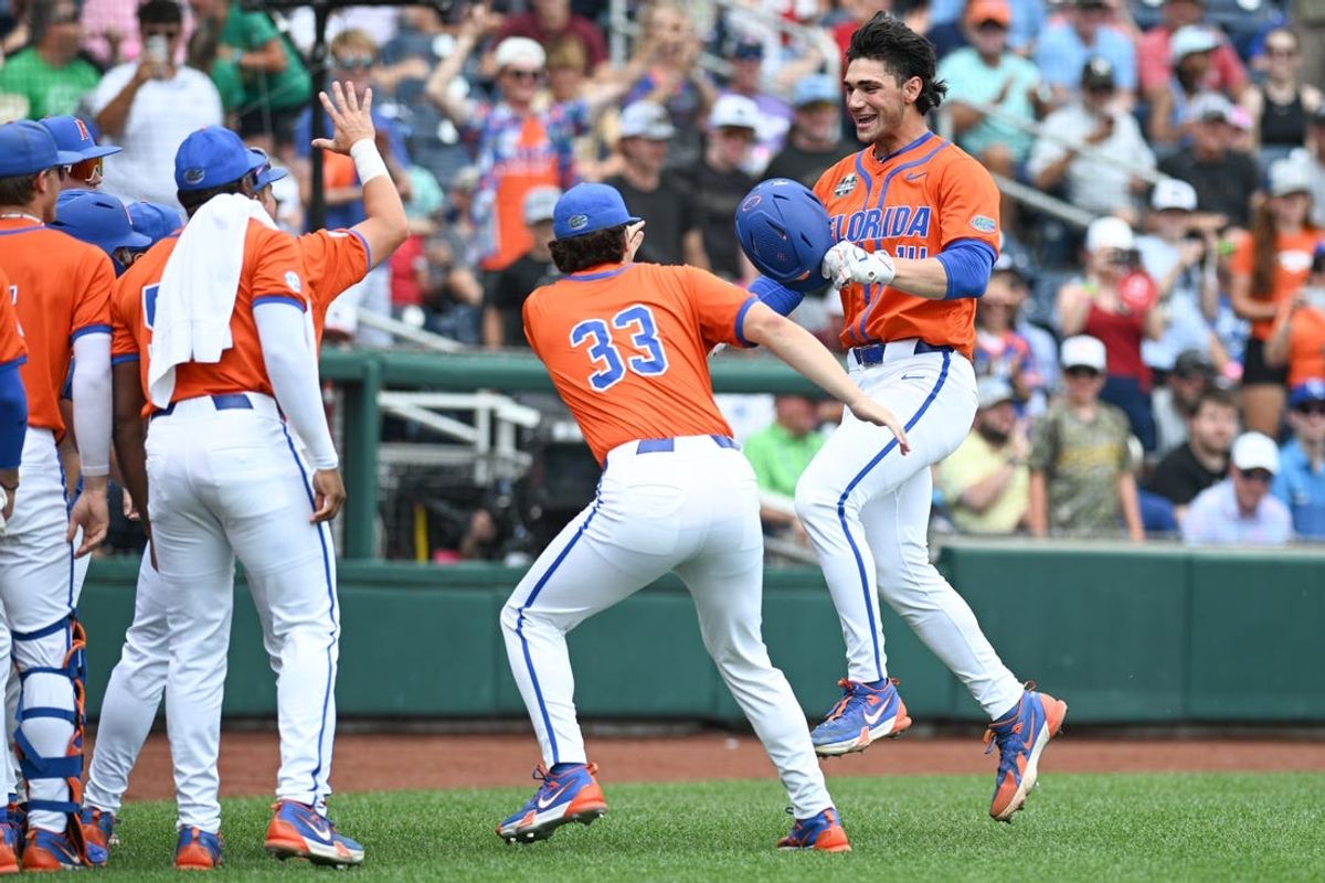 Jun 17, 2024; Omaha, NE, USA;  Florida Gators starting pitcher/designated hitter Jac Caglianone (14) celebrates with pitcher Robert Satin (33) after hitting a three run home run against the NC State Wolfpack during the second inning at Charles Schwab Field Omaha. Mandatory Credit: Steven Branscombe-USA TODAY Sports