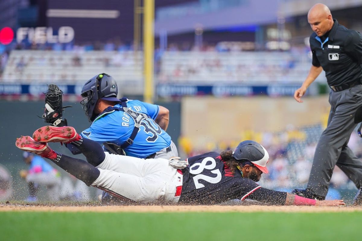 Jun 18, 2024; Minneapolis, Minnesota, USA; Minnesota Twins outfielder Austin Martin (82) slides home against the Tampa Bay Rays catcher Ben Rortvedt (30) in the fourth inning at Target Field. Mandatory Credit: Brad Rempel-USA TODAY Sports