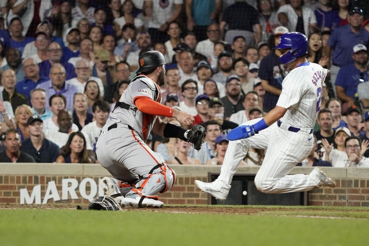 Jun 18, 2024; Chicago, Illinois, USA; San Francisco Giants catcher Curt Casali (18) tags out Chicago Cubs outfielder Seiya Suzuki (27) during the eighth inning at Wrigley Field. Mandatory Credit: David Banks-USA TODAY Sports
