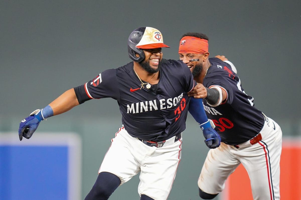 Jun 18, 2024; Minneapolis, Minnesota, USA; Minnesota Twins first base Carlos Santana (30) celebrates his game winning hit with second base Willi Castro (50) against the Tampa Bay Rays in the ninth inning at Target Field. Mandatory Credit: Brad Rempel-USA TODAY Sports