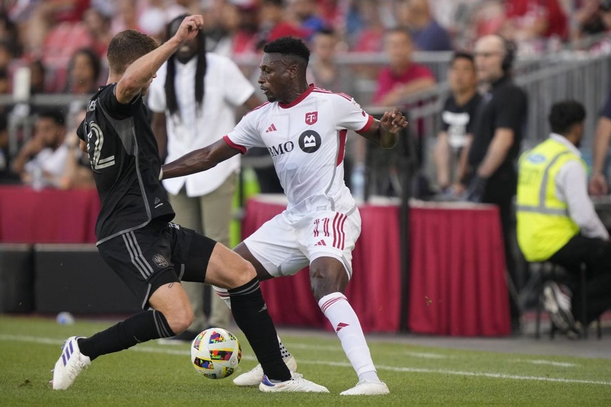 Jun 19, 2024; Toronto, Ontario, CAN; Toronto FC midfielder Derrick Etienne (11) plays the ball defend by Nashville SC defender Josh Bauer (22) in the first half at BMO Field. Mandatory Credit: John E. Sokolowski-USA TODAY Sports