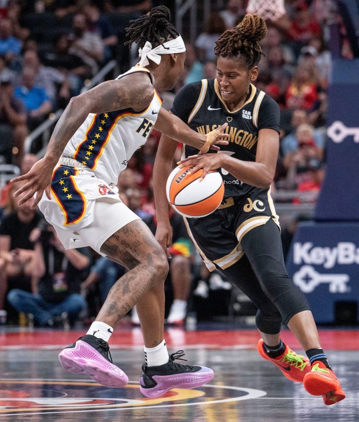 Washington Mystics guard Ariel Atkins (7) rushes up the court against Indiana Fever guard Erica Wheeler (17) Wednesday, June 19, 2024, during the game at Gainbridge Fieldhouse in Indianapolis.