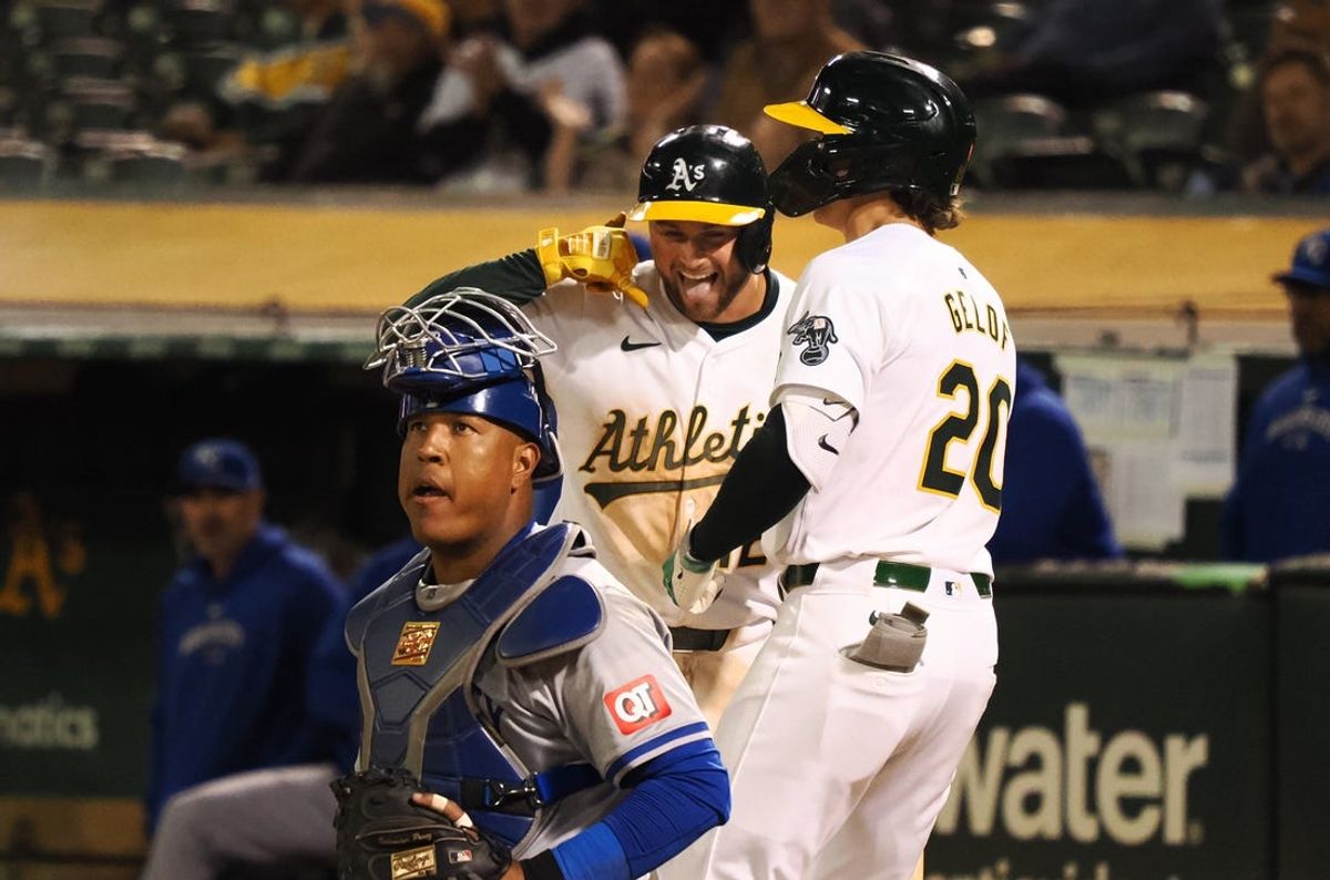 Jun 19, 2024; Oakland, California, USA; Oakland Athletics shortstop Max Shuemann (12) celebrates with second baseman Zack Gelof (20) behind Kansas City Royals catcher Salvador Perez (13) after Gelof hit a solo home run during the eighth inning at Oakland-Alameda County Coliseum. Mandatory Credit: Kelley L Cox-USA TODAY Sports