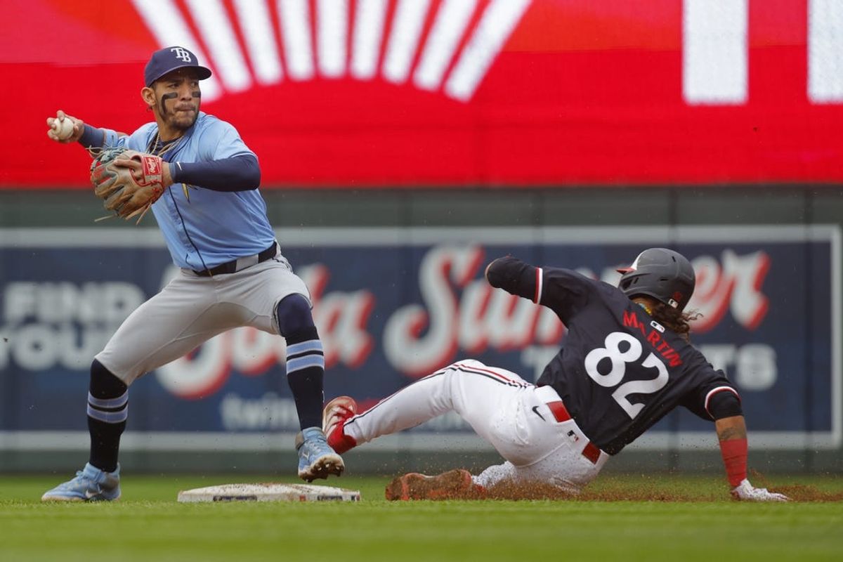 Jun 20, 2024; Minneapolis, Minnesota, USA; Tampa Bay Rays shortstop Jose Caballero (7) forces out Minnesota Twins second baseman Austin Martin (82) and turns the double play in the fifth inning at Target Field. Mandatory Credit: Bruce Kluckhohn-USA TODAY Sports