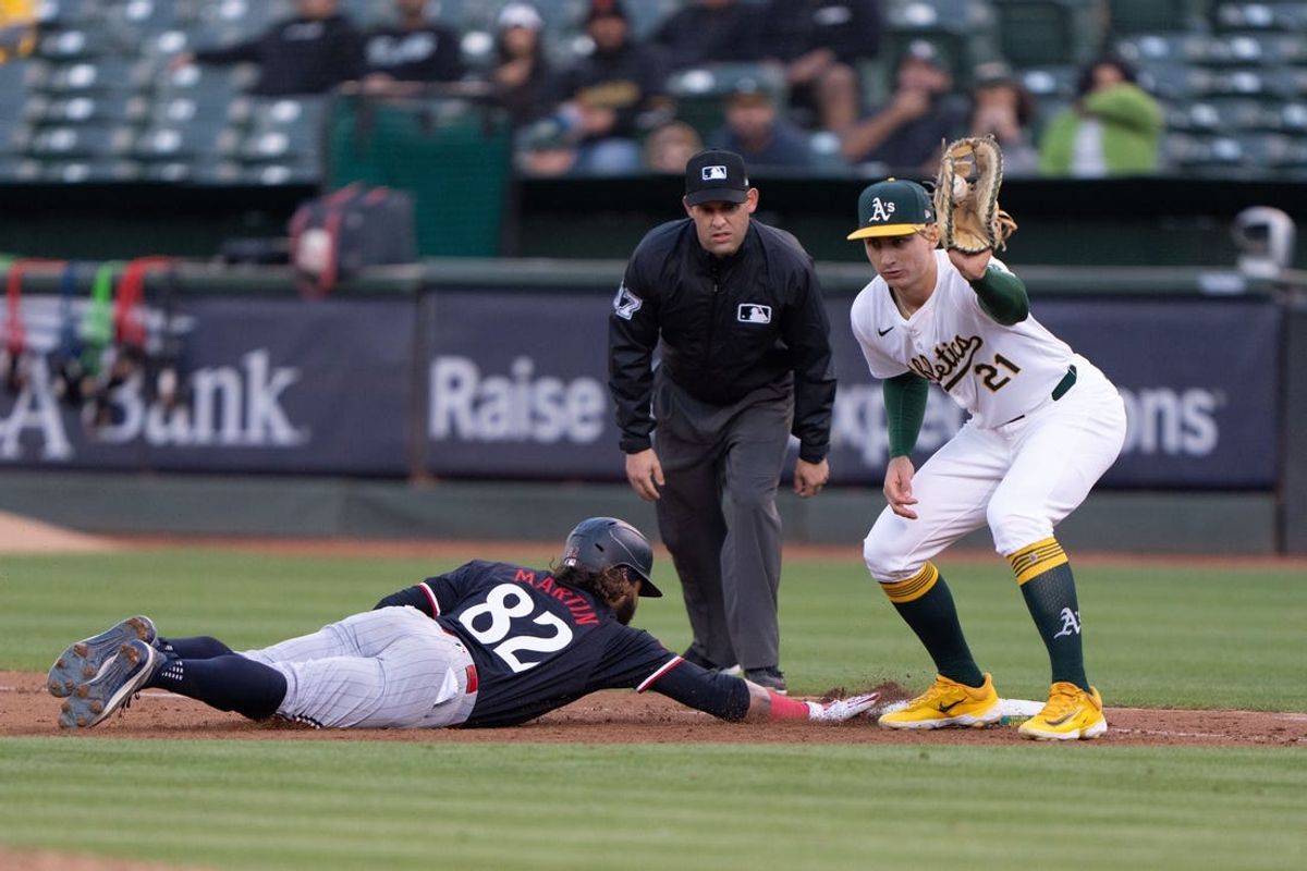Jun 21, 2024; Oakland, California, USA; Minnesota Twins outfielder Austin Martin (82) slides back to first base against Oakland Athletics first base Tyler Soderstrom (21) during the fifth inning at Oakland-Alameda County Coliseum. Mandatory Credit: Stan Szeto-USA TODAY Sports