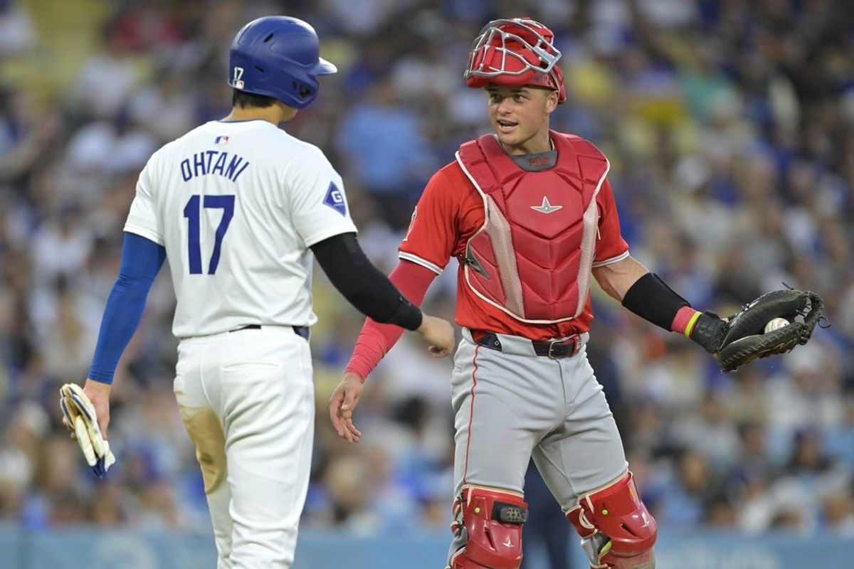 Jun 21, 2024; Los Angeles, California, USA;  Los Angeles Dodgers designated hitter Shohei Ohtani (17) laughs with Los Angeles Angels catcher Logan O'Hoppe (14) during a pitching change in the third inning at Dodger Stadium. Mandatory Credit: Jayne Kamin-Oncea-USA TODAY Sports