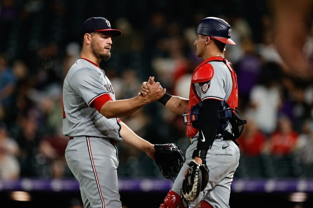 Jun 21, 2024; Denver, Colorado, USA; Washington Nationals pitcher Tanner Rainey (21) celebrates with catcher Drew Millas (81) after the game against the Colorado Rockies at Coors Field. Mandatory Credit: Isaiah J. Downing-USA TODAY Sports