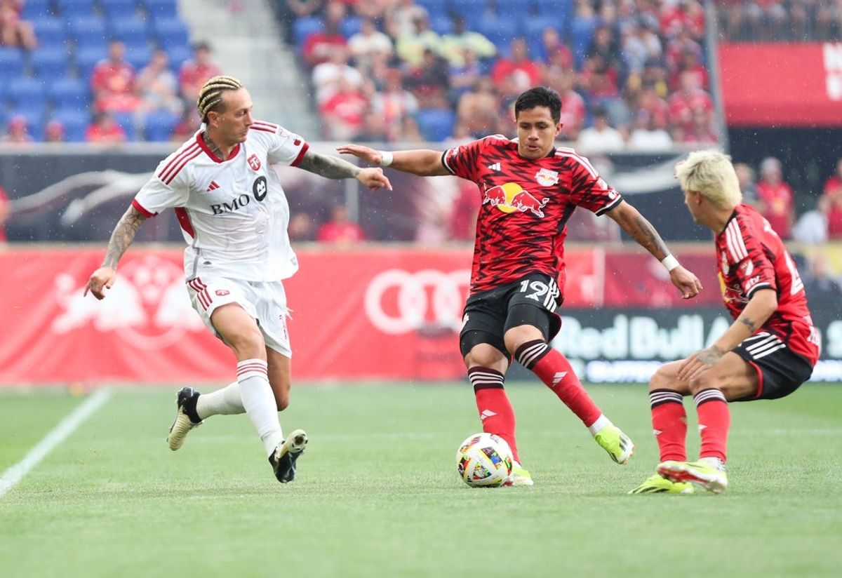 Jun 22, 2024; Harrison, New Jersey, USA; New York Red Bulls midfielder Wikelman Carmona (19) dribbles the ball against Toronto FC forward Federico Bernardeschi (10) during the first half at Red Bull Arena. Mandatory Credit: Tom Horak-USA TODAY Sports
