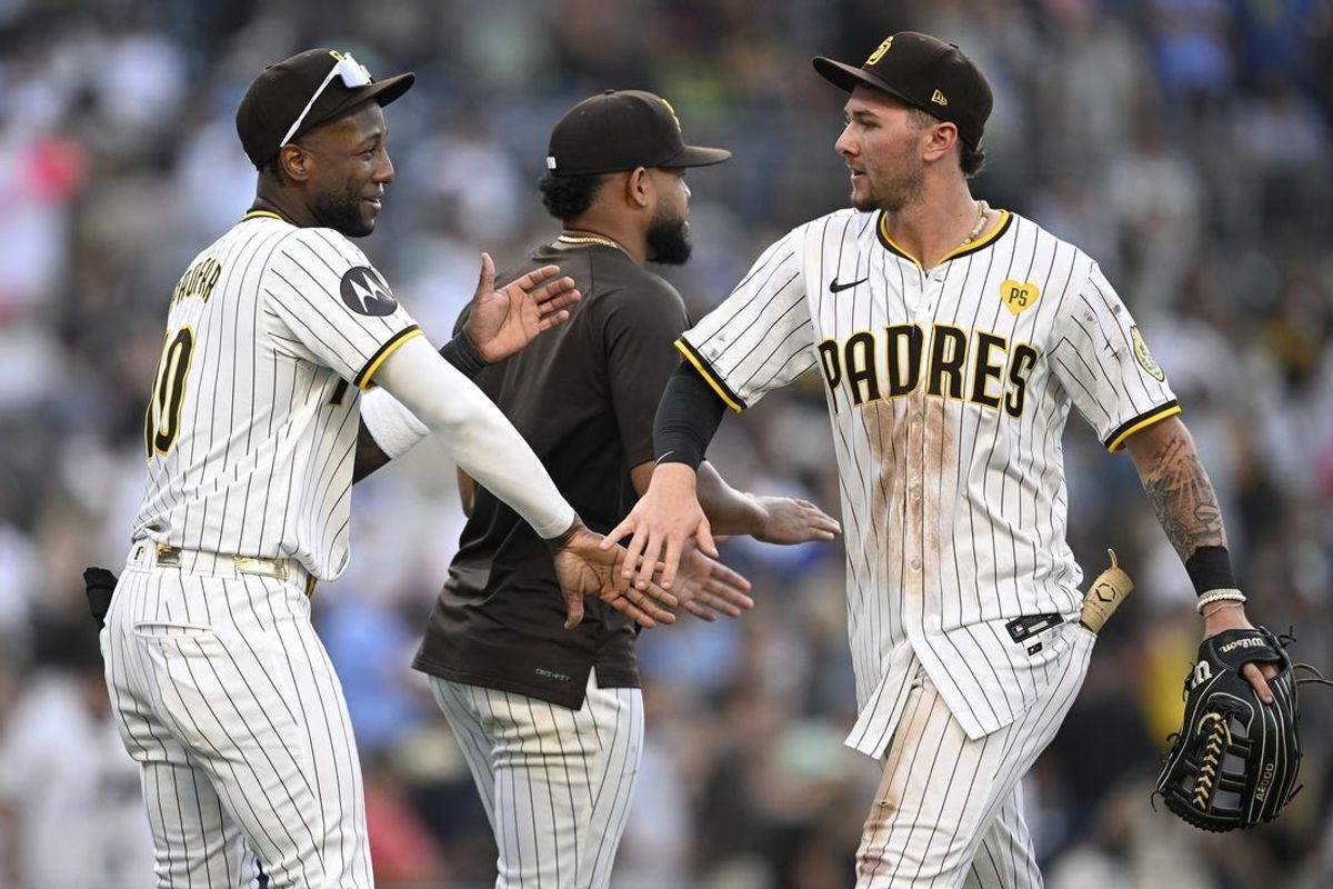 Jun 22, 2024; San Diego, California, USA; San Diego Padres center fielder Jackson Merrill (right) and left fielder Jurickson Profar (10) celebrate on the field after defeating the Milwaukee Brewers at Petco Park. Mandatory Credit: Orlando Ramirez-USA TODAY Sports