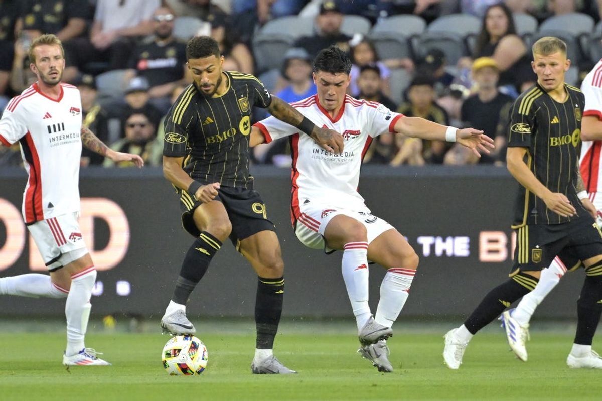 Jun 22, 2024; Los Angeles, California, USA;   LAFC forward Denis Bouanga (99) and San Jose Earthquakes midfielder Niko Tsakiris (30) battle for the ball in the first half at BMO Stadium. Mandatory Credit: Jayne Kamin-Oncea-USA TODAY Sports