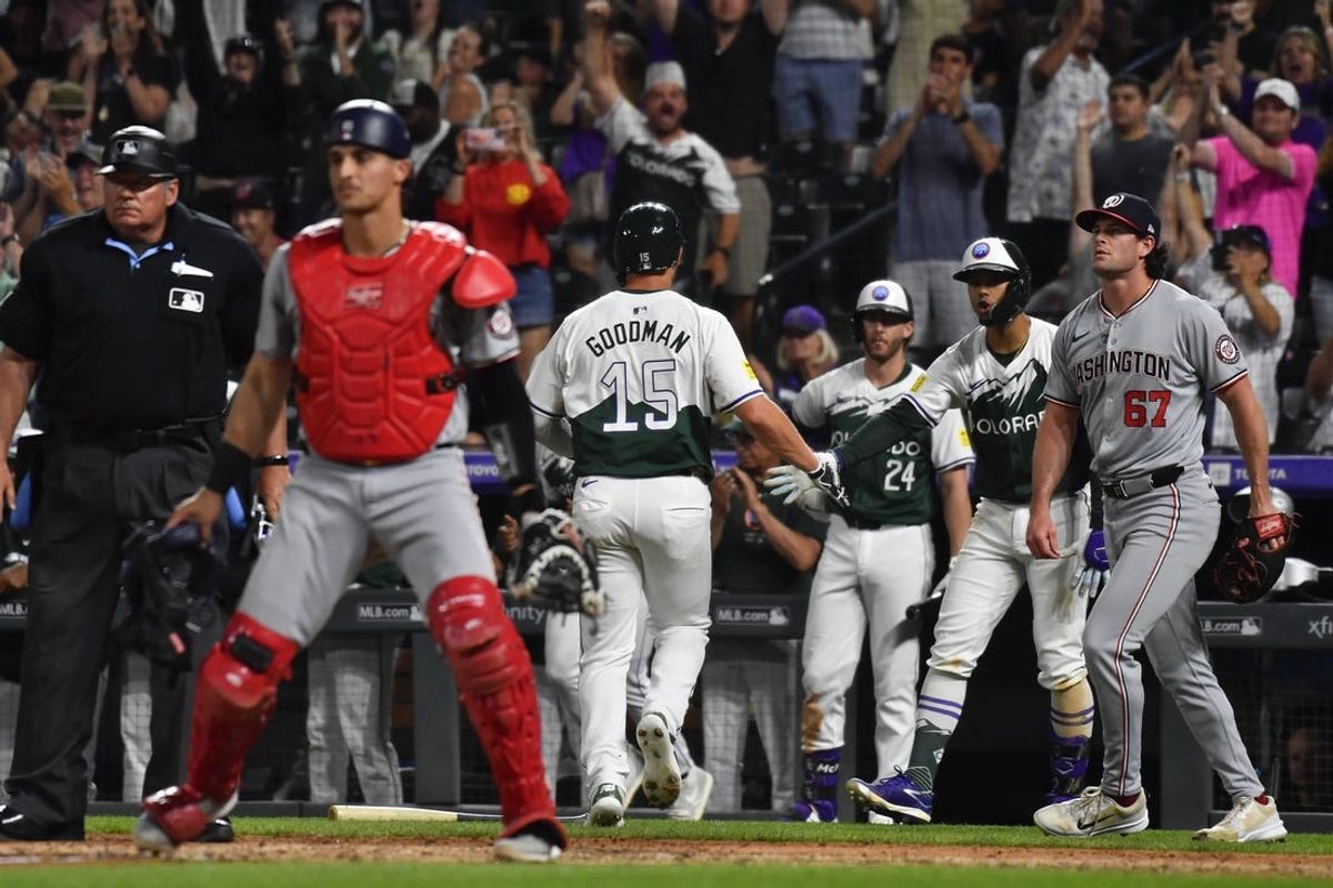 Jun 22, 2024; Denver, Colorado, USA; Colorado Rockies designated hitter Hunter Goodman (15) is greeted by shortstop Ezequiel Tovar (14) after scoring the tying run against the Washington Nationals in the ninth inning at Coors Field. Mandatory Credit: John Leyba-USA TODAY Sports