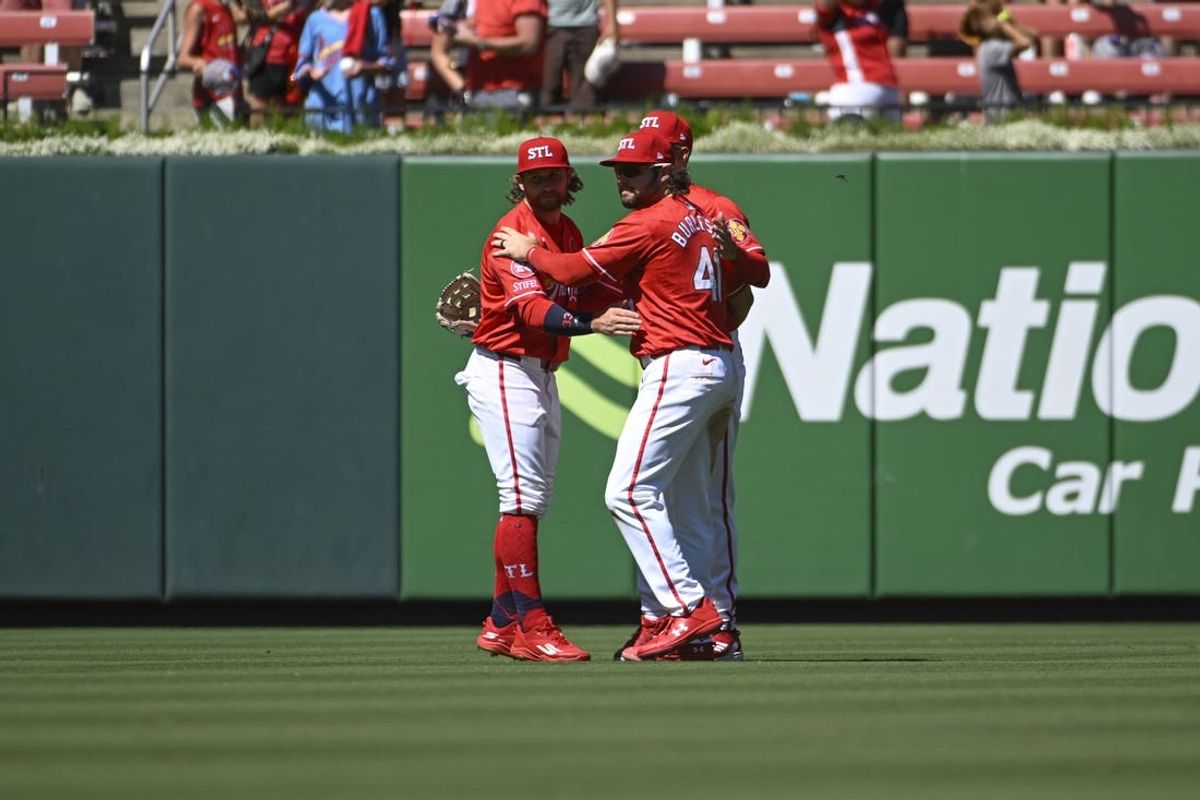 Jun 23, 2024; St. Louis, Missouri, USA; St. Louis Cardinals left fielder Brendan Donovan (33), right fielder Dylan Carlson (3) and right fielder Alec Burleson (41) celebrate a victory over the San Francisco Giants at Busch Stadium. Mandatory Credit: Joe Puetz-USA TODAY Sports