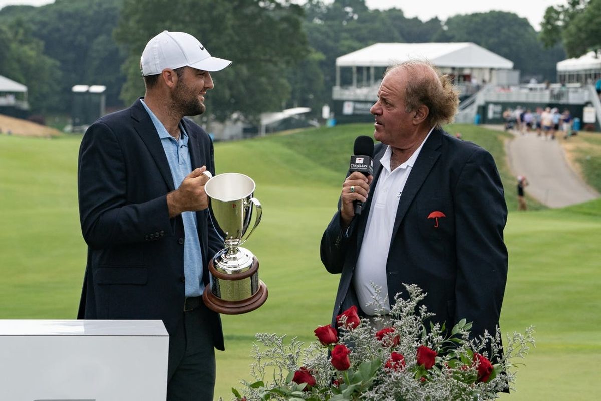 Jun 23, 2024; Cromwell, Connecticut, USA;  Scottie Scheffler hold the Travelers Championship Trophy while speaking with Chris Berman during the final round of the Travelers Championship golf tournament at TPC River Highlands. Mandatory Credit: Gregory Fisher-USA TODAY Sports